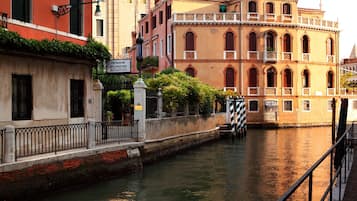 A canal with buildings on either side, including a sign for 'Pensione Accademia' and a building with arched windows.