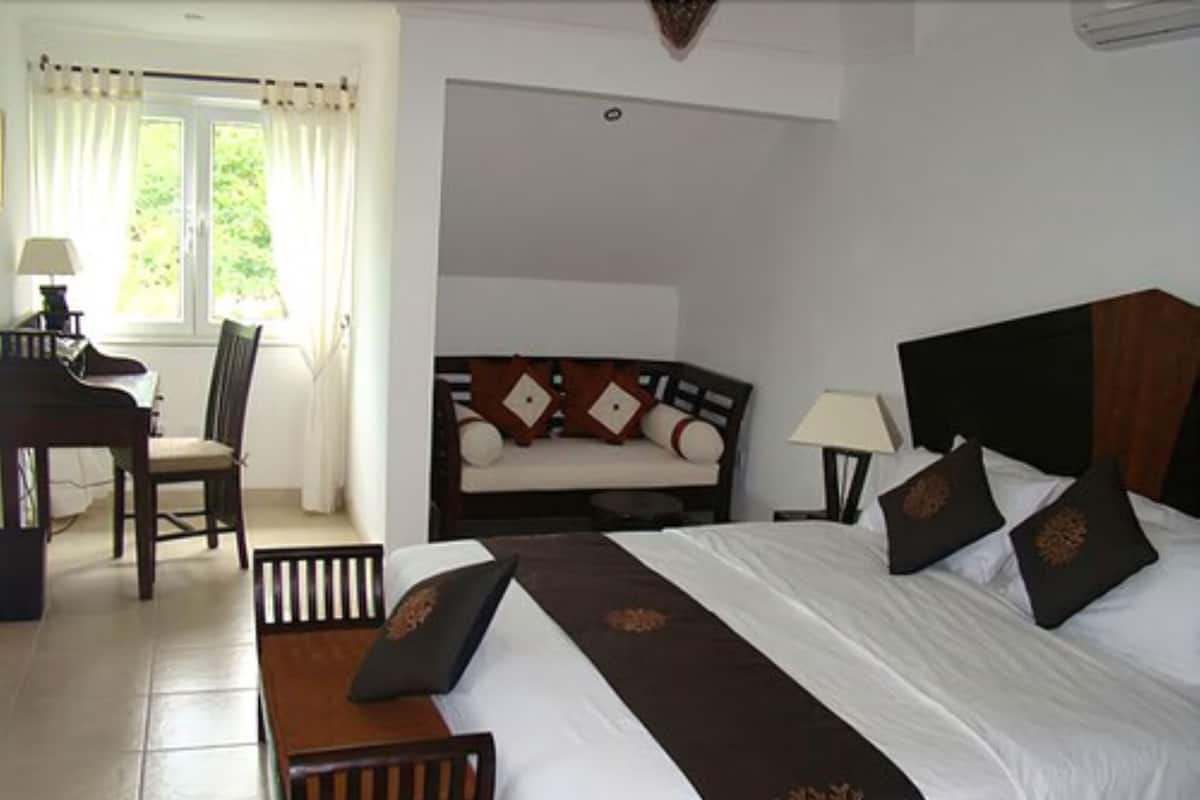Una habitación de hotel con una cama, un escritorio y una silla.