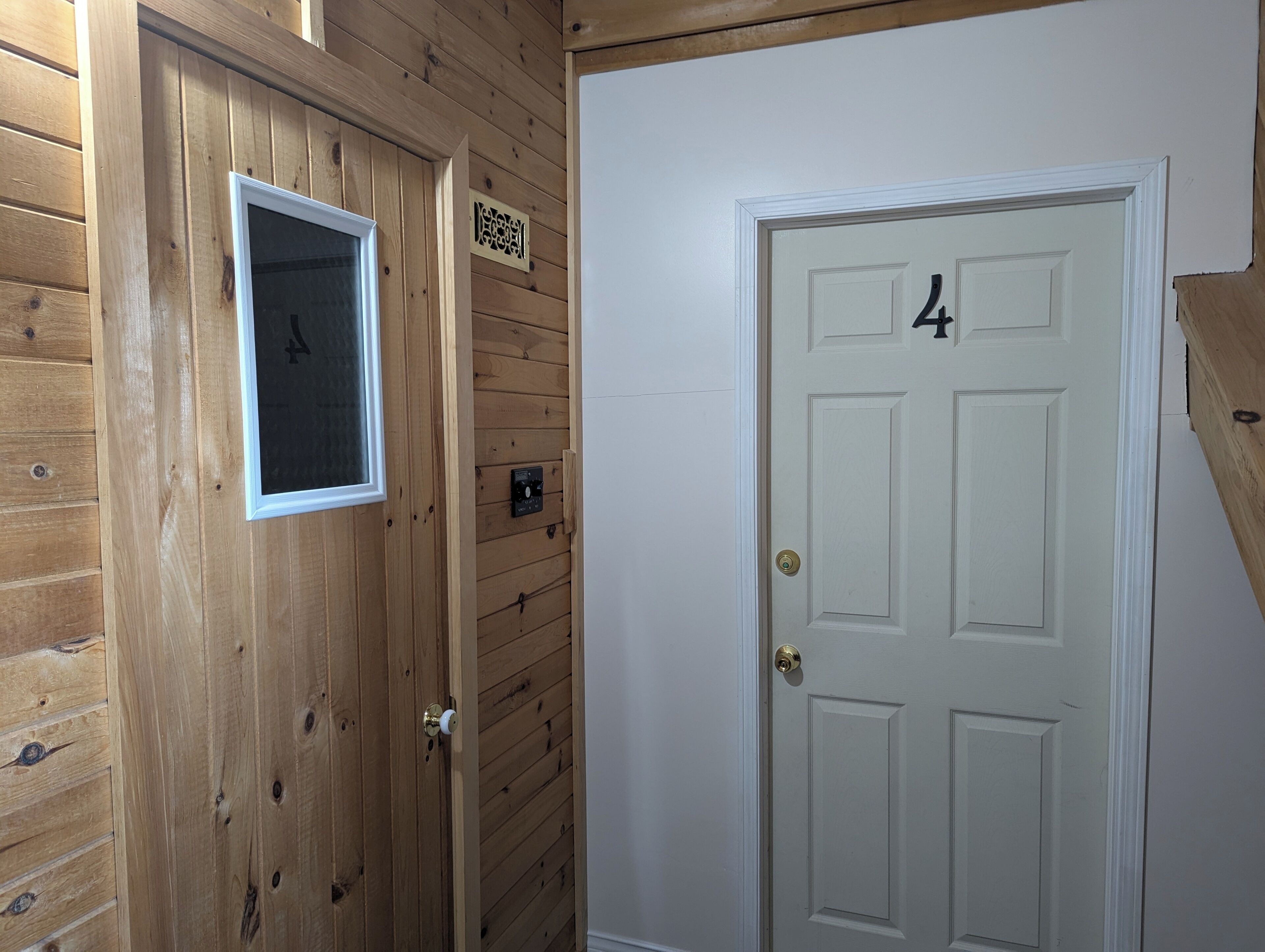 A wooden door with a window and a door number '4'.