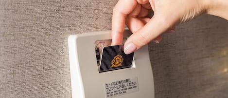 Una mano insertando una tarjeta en un lector de tarjetas en una máquina blanca.