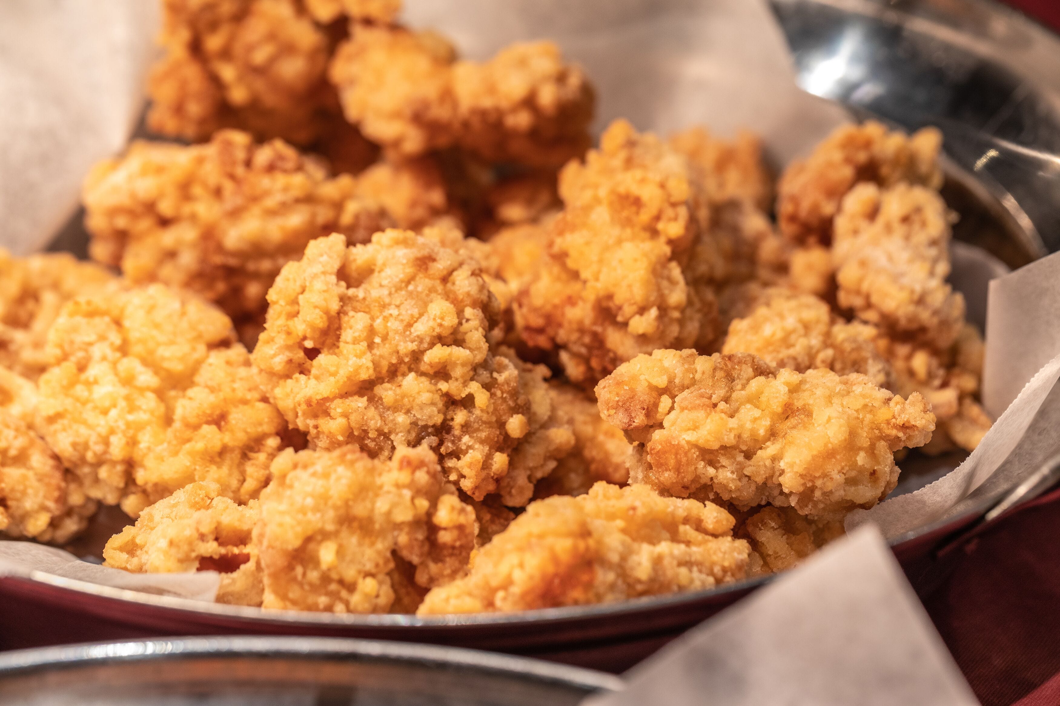 Primer plano de una bandeja llena de piezas de pollo frito doradas.
