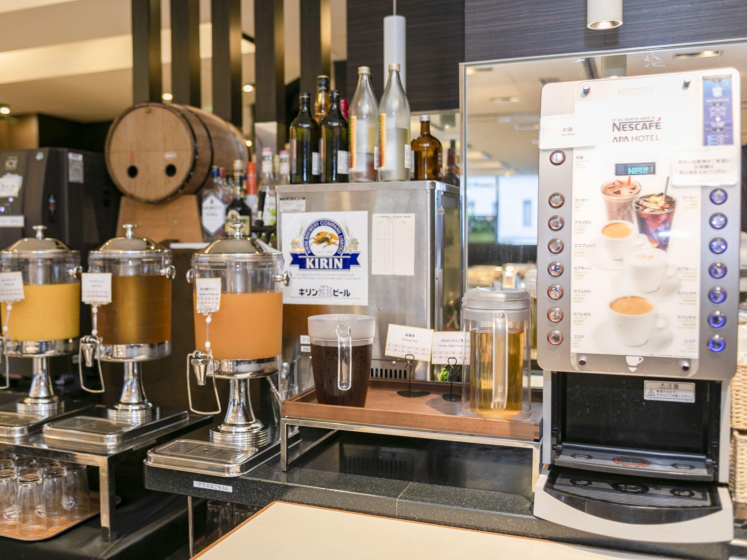 A bar area with a Nescafé machine, various drink dispensers, and a Kirin beer tap.