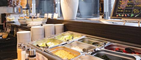 A buffet setup with various food items and condiments.