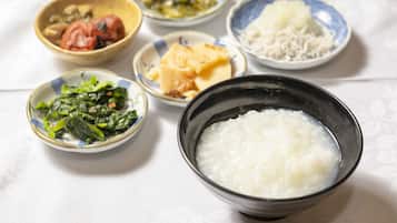 A table with various dishes including a bowl of rice, a bowl of soup, and several small dishes with different foods.