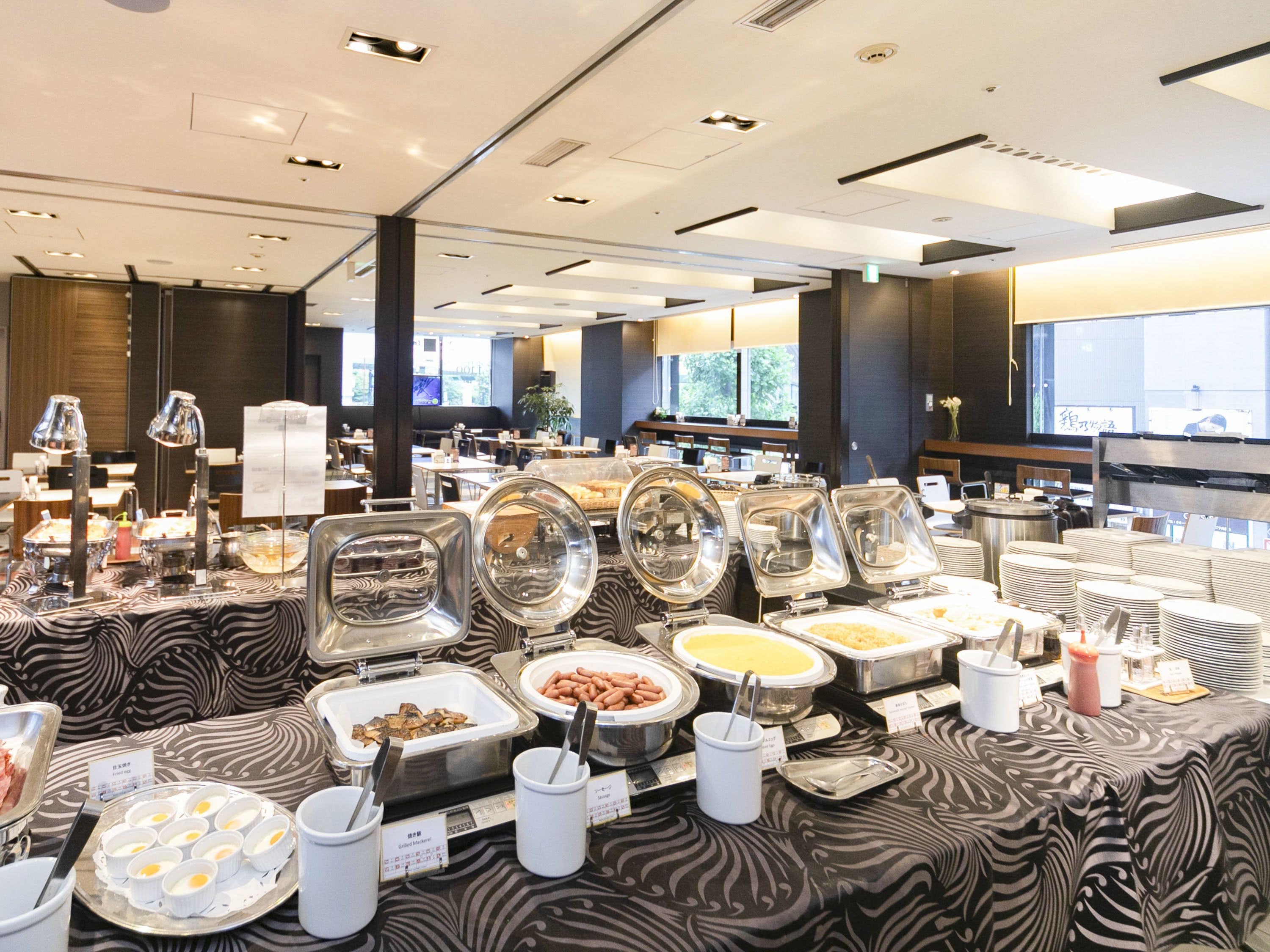A buffet setup with various food items and utensils.