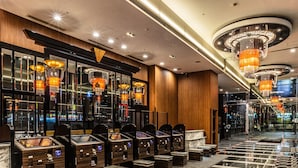 A hotel lobby with a modern design, featuring a marble floor, wooden paneling, and multiple reception desks.
