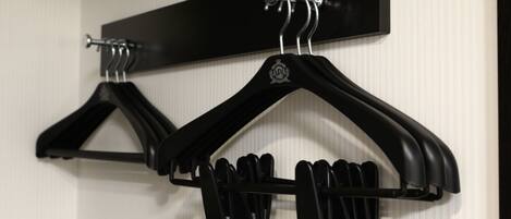 A wall-mounted coat rack with two black hangers.