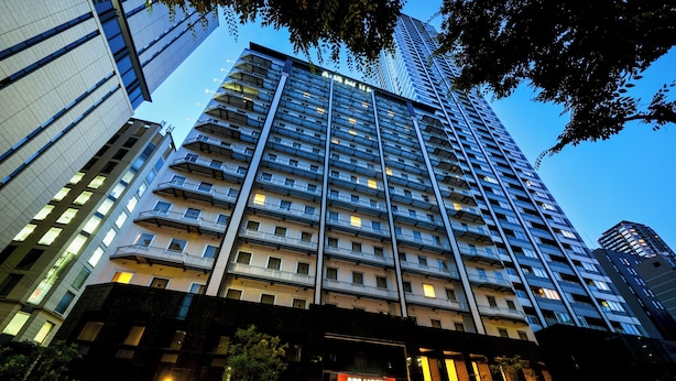 A multi-story hotel with a modern facade, large windows, and a well-lit entrance. - APA Hotel Yodoyabashi Ekimae (Osaka)