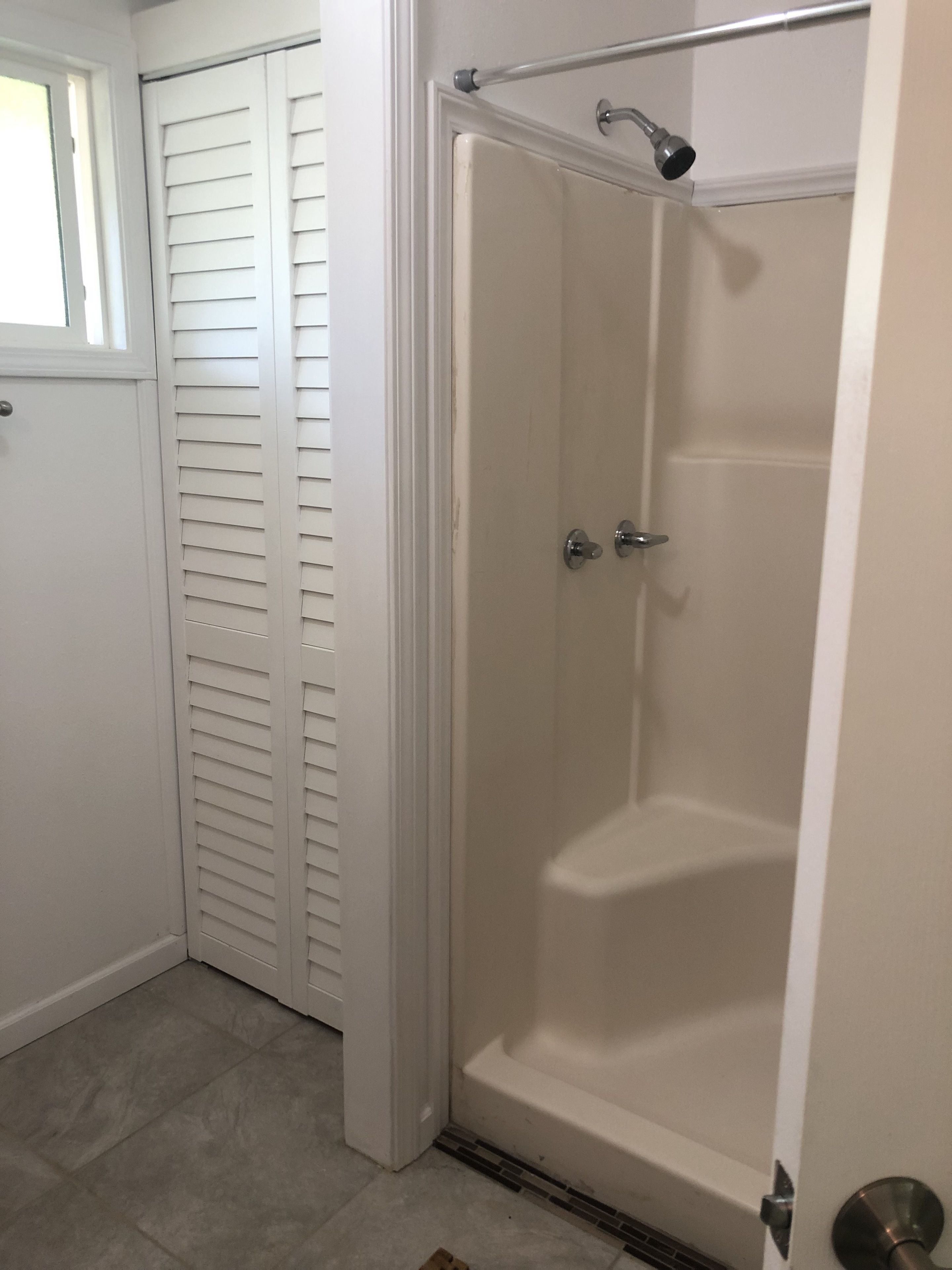 Ein Badezimmer mit bodengleicher Dusche, Toilette und Waschbecken.