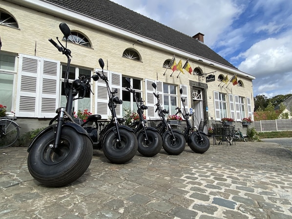 A building with a row of electric bicycles parked outside. - Horenbecca (Horebeke)