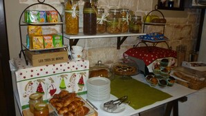 Una barra de buffet con diversos alimentos, entre ellos pasteles, salsas y bebidas.