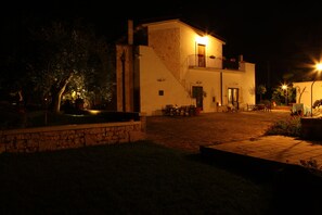 A two-story building with a stone facade, a balcony, and outdoor seating. - Masseria Sant'Angelo (Monopoli)