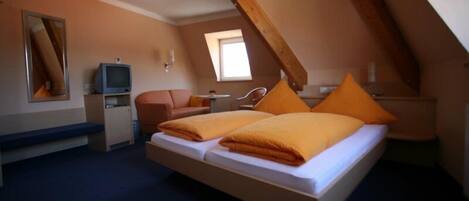 Un dormitorio con cama estilo loft, escritorio, silla y televisor.