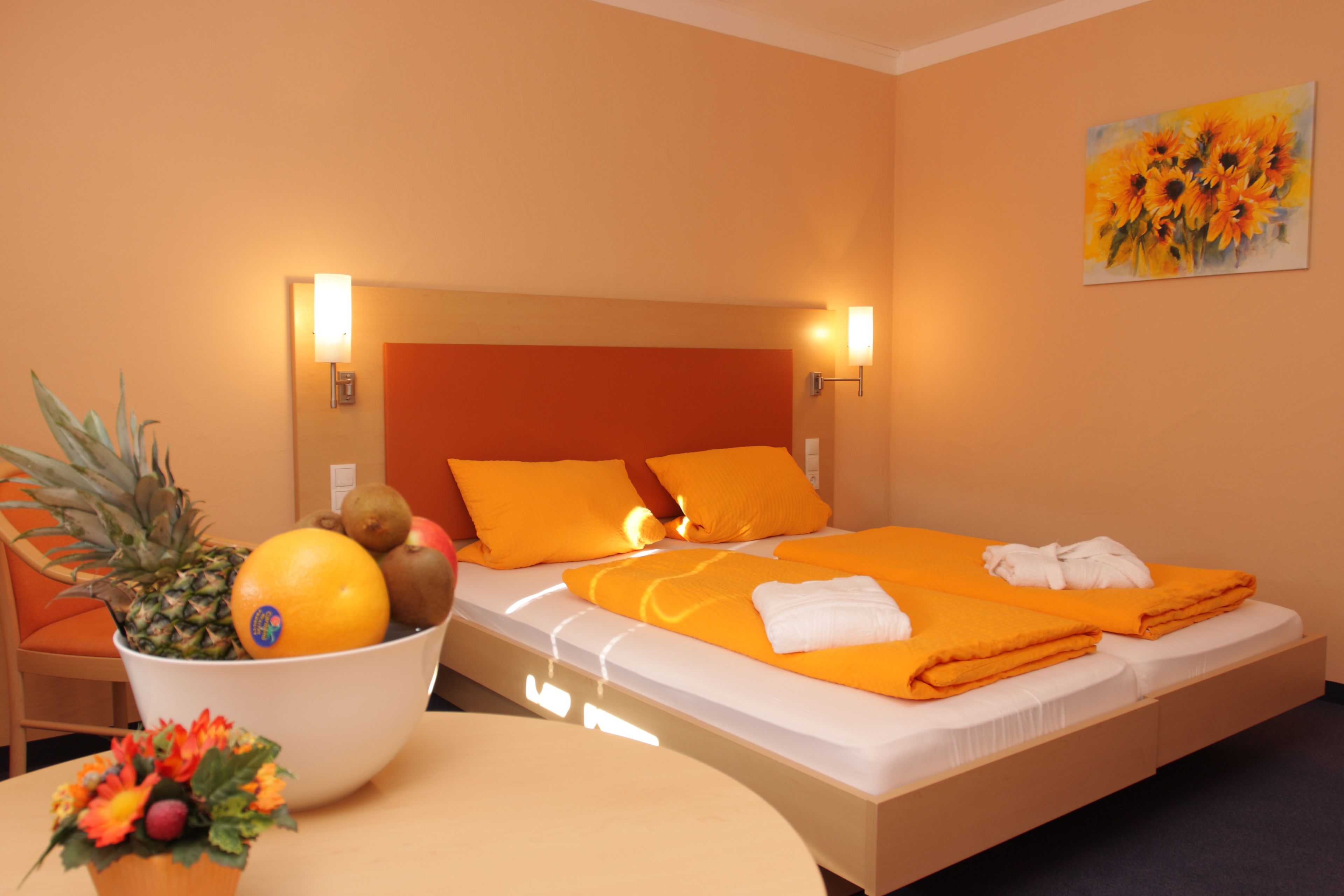 Ein Hotelzimmer mit einem Bett, einer Obstschale und einem Bild an der Wand.