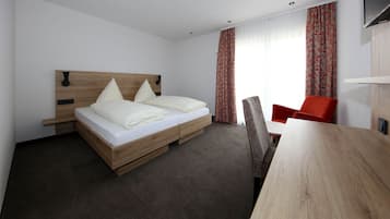 Een moderne hotelkamer met een houten bed, een bureau en een stoel.