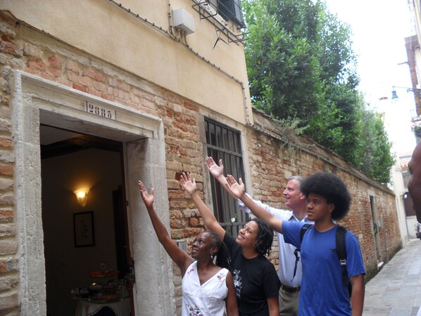 A narrow alley with a building entrance, a visible number "2885", and a person with raised hands. - Santa Margherita Guesthouse (Venice)