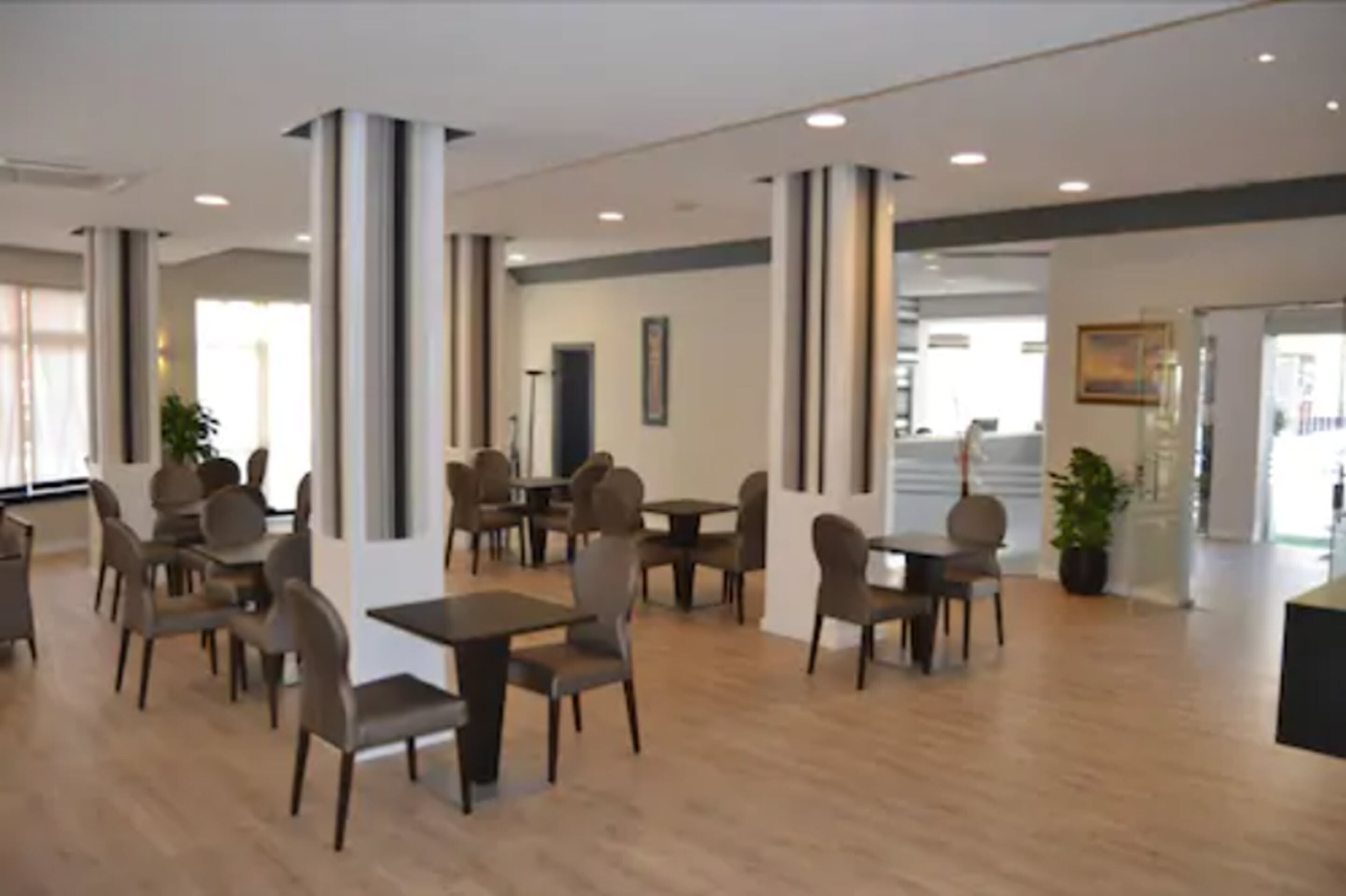 Un vaste espace intérieur doté de nombreuses tables et chaises, de grandes colonnes et d’un design moderne.