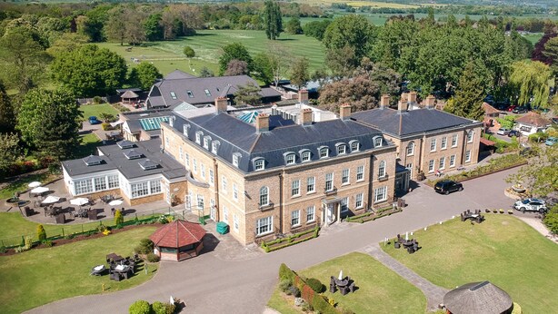 A large, historic building with a spacious courtyard, surrounded by well-maintained gardens and a scenic countryside view. - Orsett Hall Hotel (Grays)