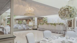 A banquet hall with round tables set for a formal event, featuring white tablecloths, chairs, and floral centerpieces. - Orsett Hall Hotel (Grays)