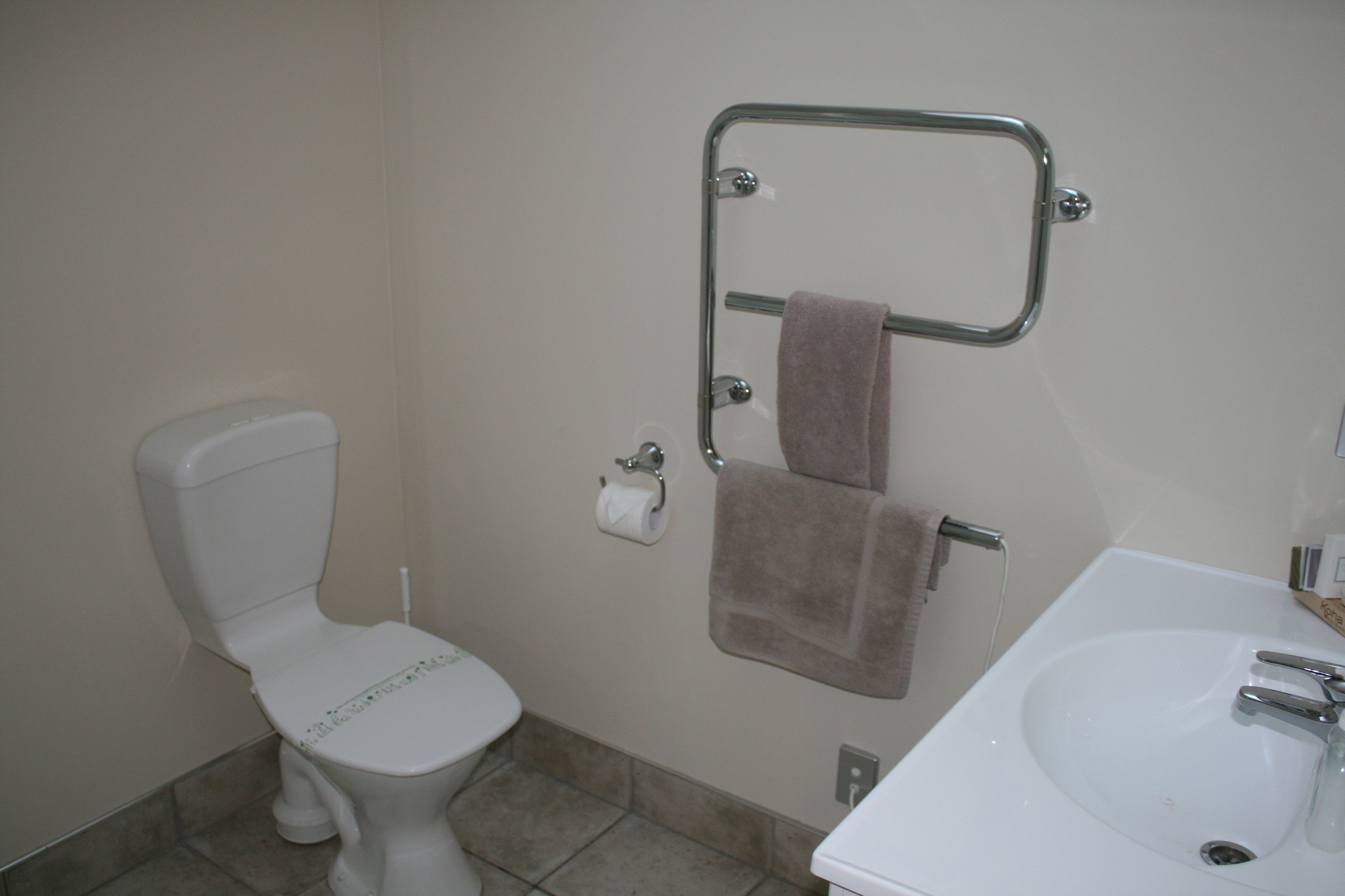 Ein Badezimmer mit Toilette, Waschbecken und Handtuchhalter.