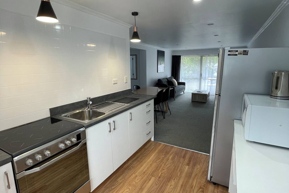 A modern kitchen with a built-in stove, sink, and refrigerator.