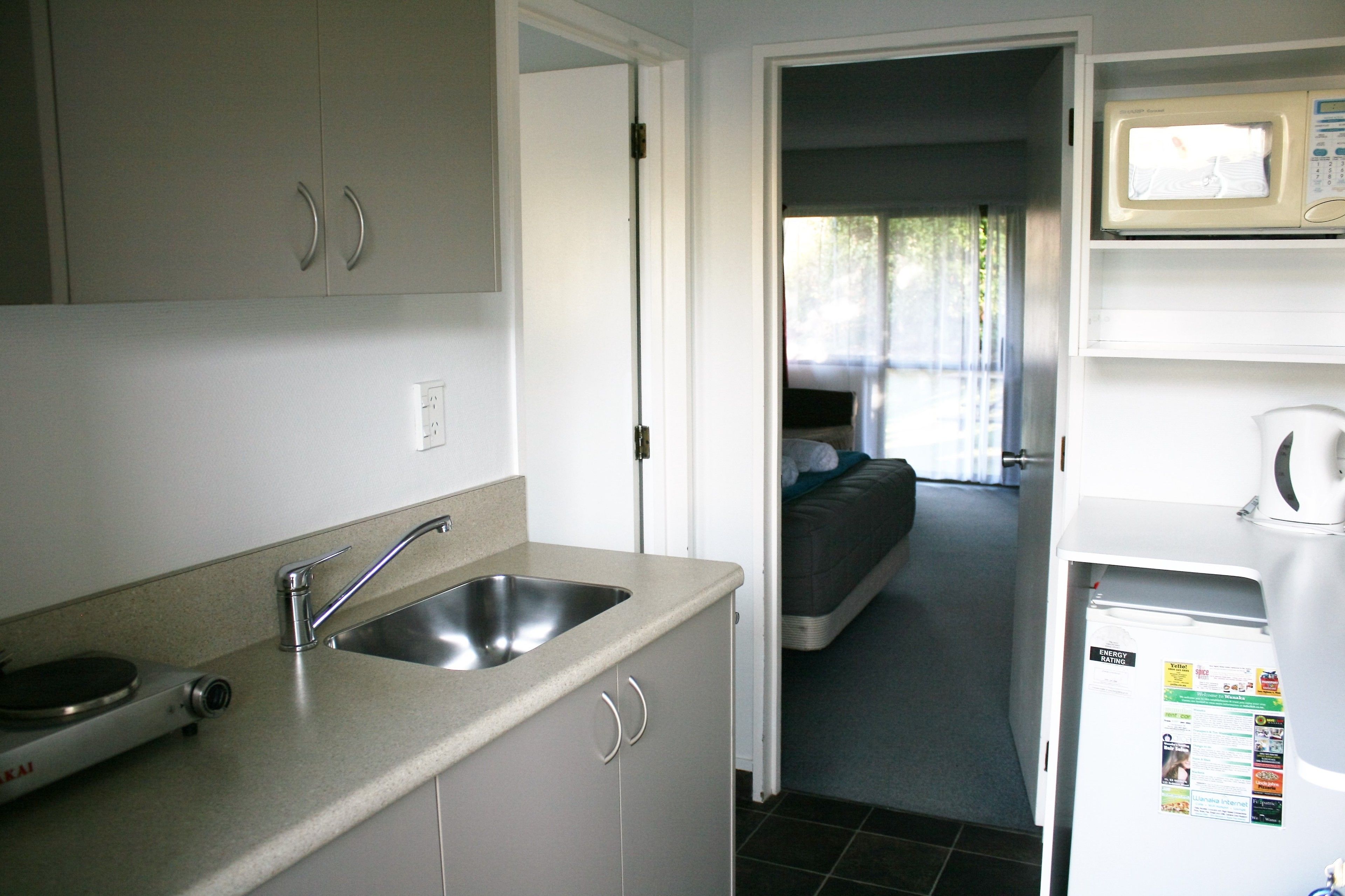 Una cocina compacta con un lavabo, un microondas y un refrigerador.