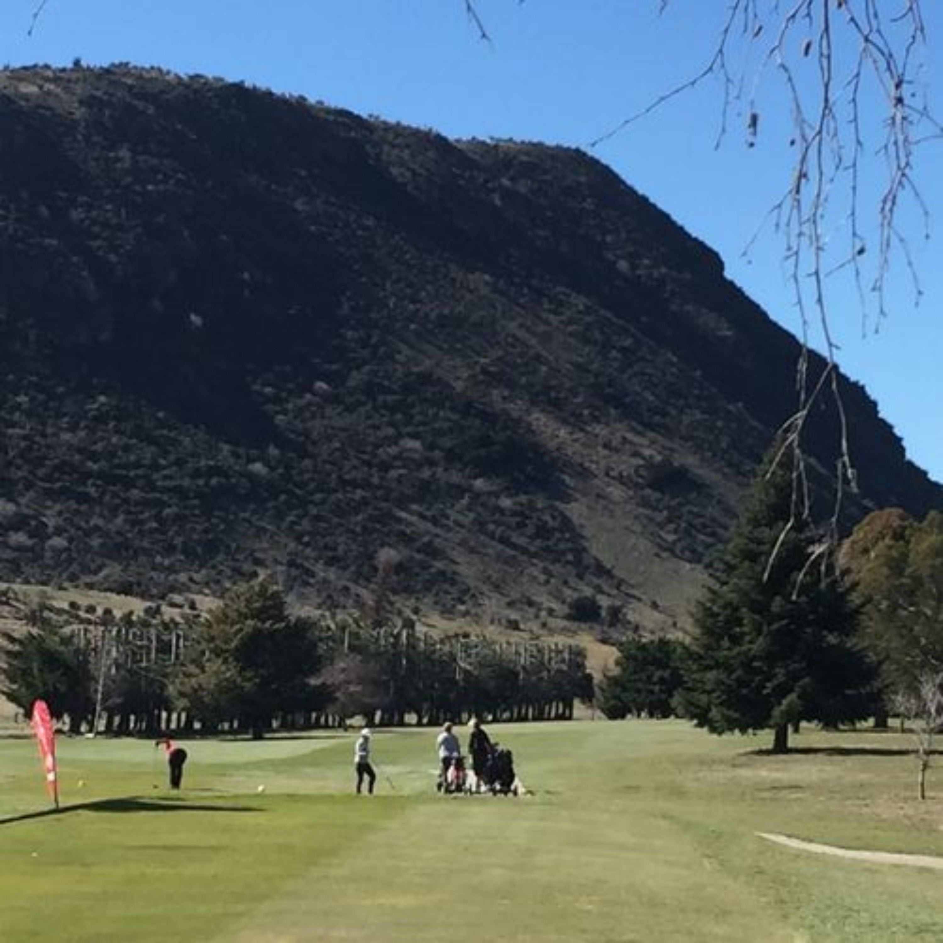 Un campo de golf con montañas al fondo.