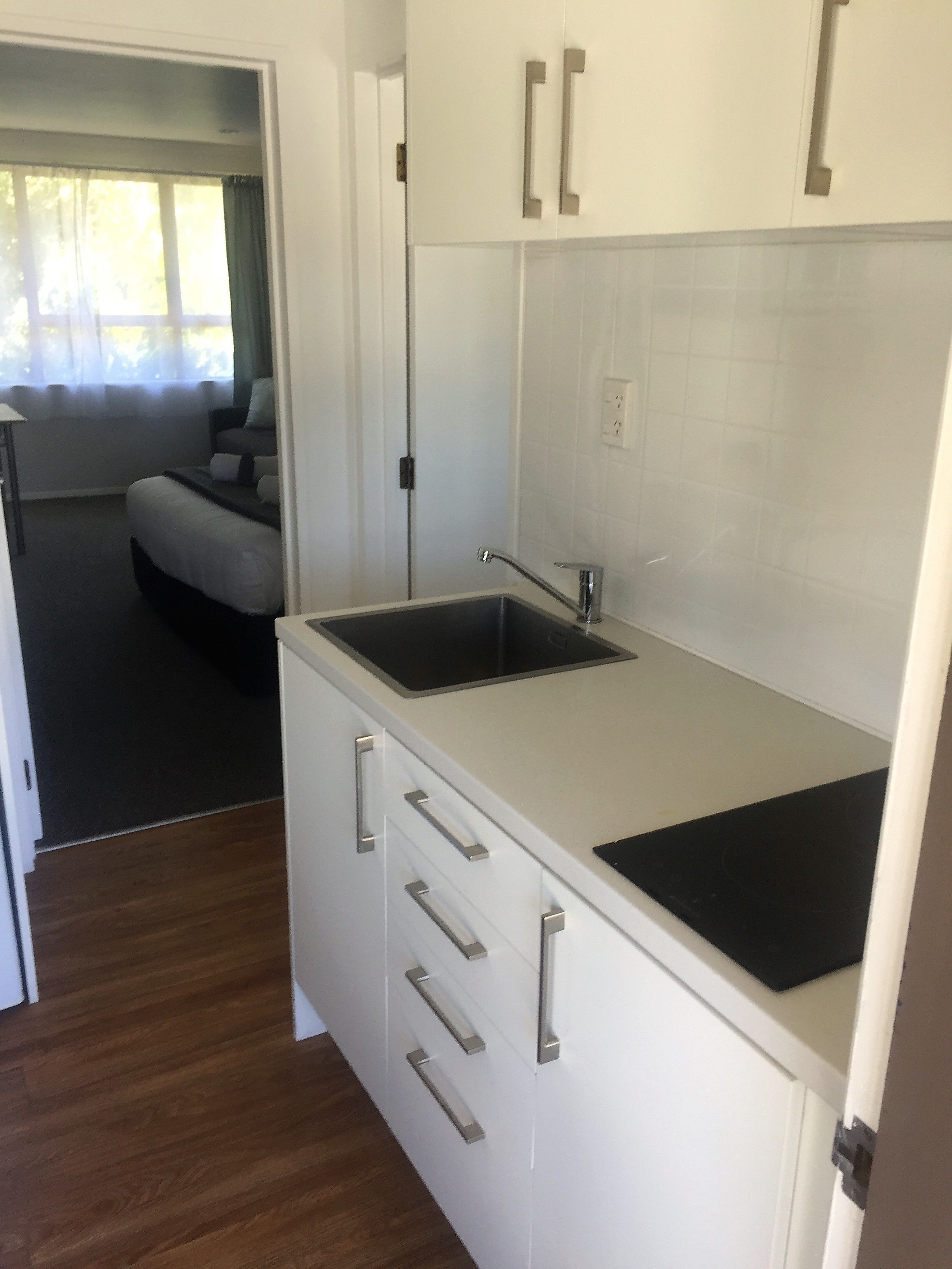 A compact kitchen with a sink, cabinets, and a countertop.