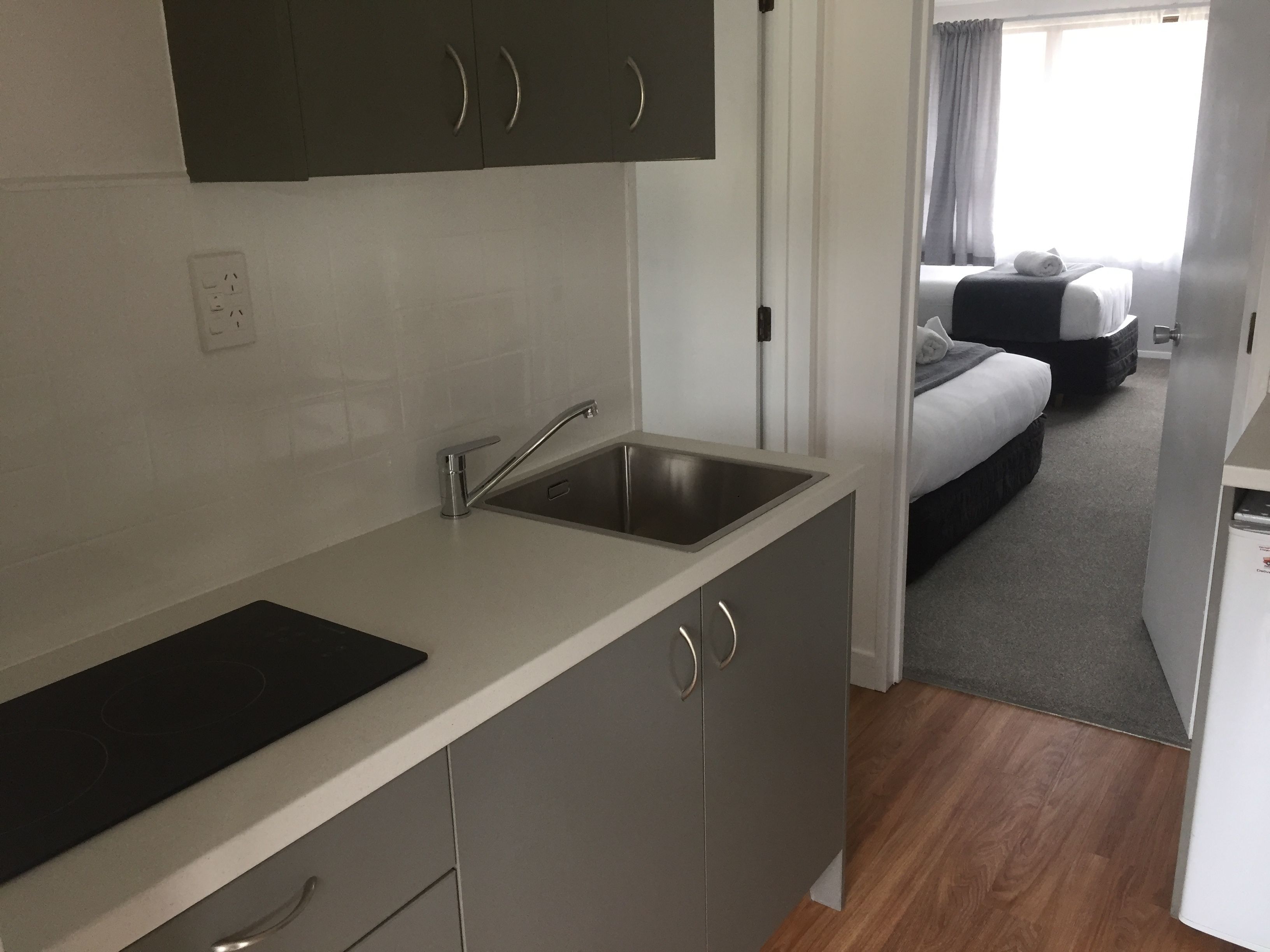 A compact kitchen with a sink, cabinets, and a countertop.