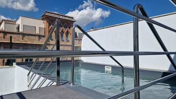 Una piscina al aire libre de temporada, sillones reclinables de piscina