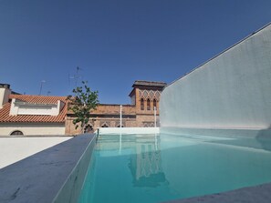 Una piscina al aire libre de temporada, tumbonas