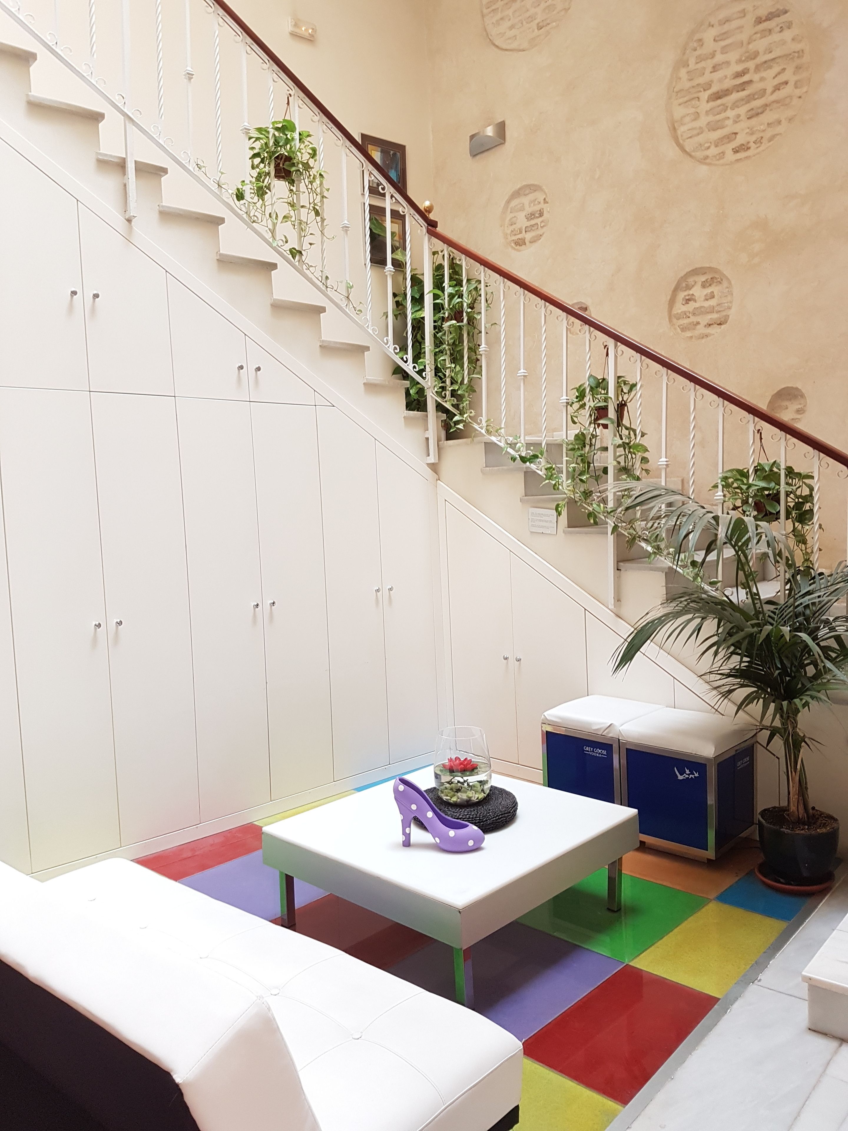 A staircase with white railings and a potted plant at the top.
