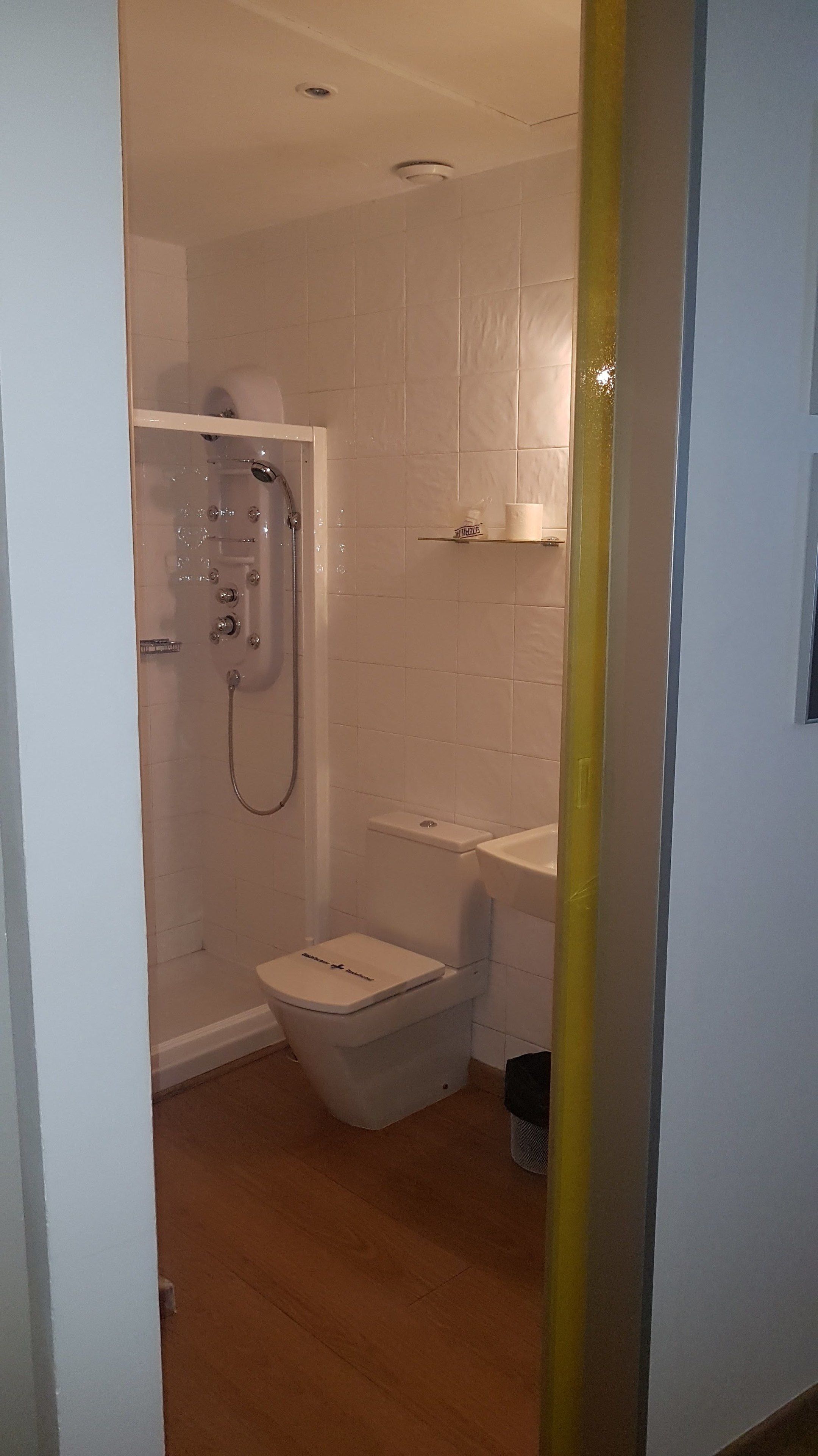 A bathroom with a shower, toilet, and sink.