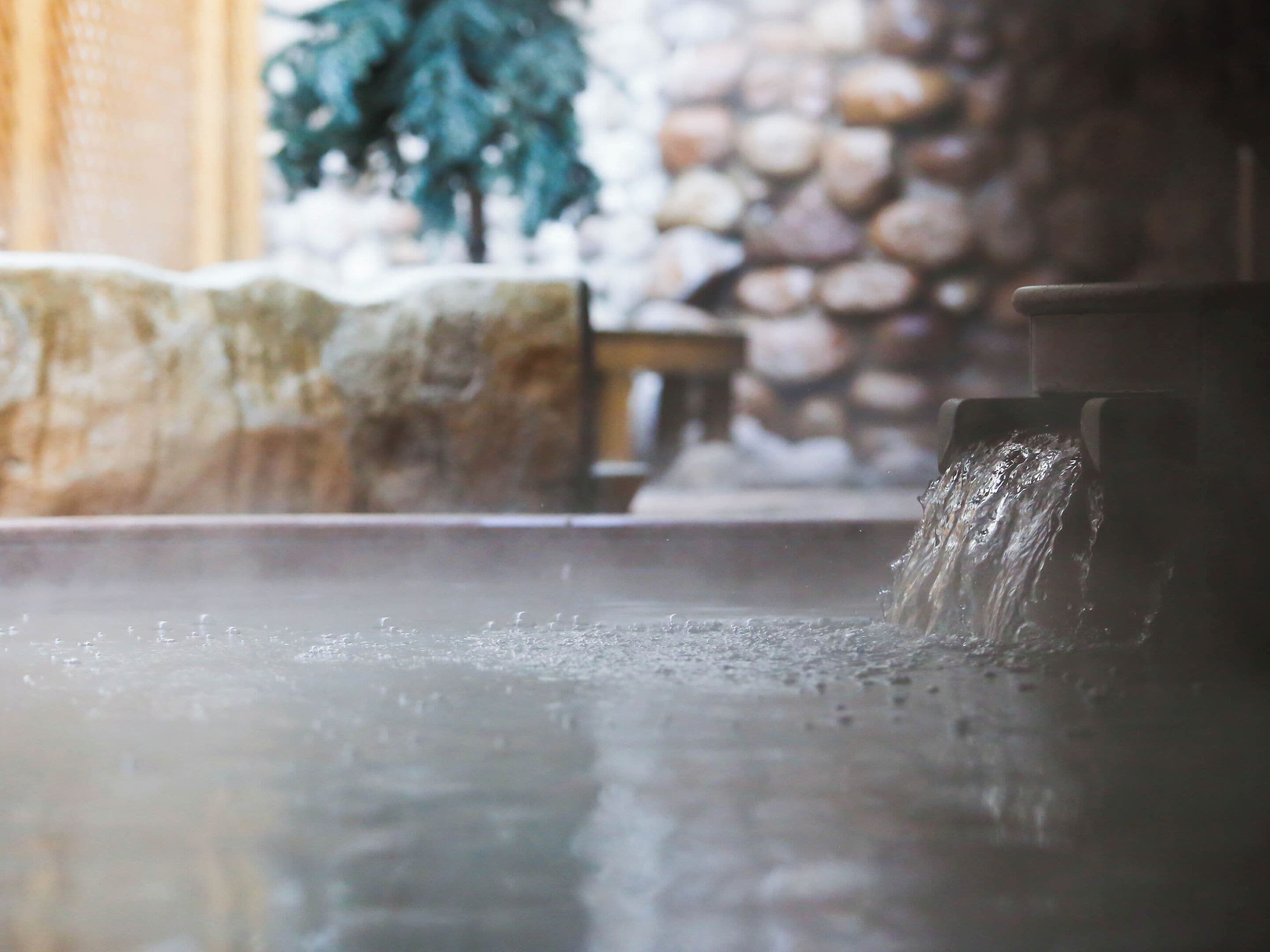 A stone wall with a water feature in a spa setting.