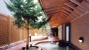A wooden ceiling, a stone wall, and a tree in a courtyard. - APA Hotel & Resort Sapporo (Sapporo)