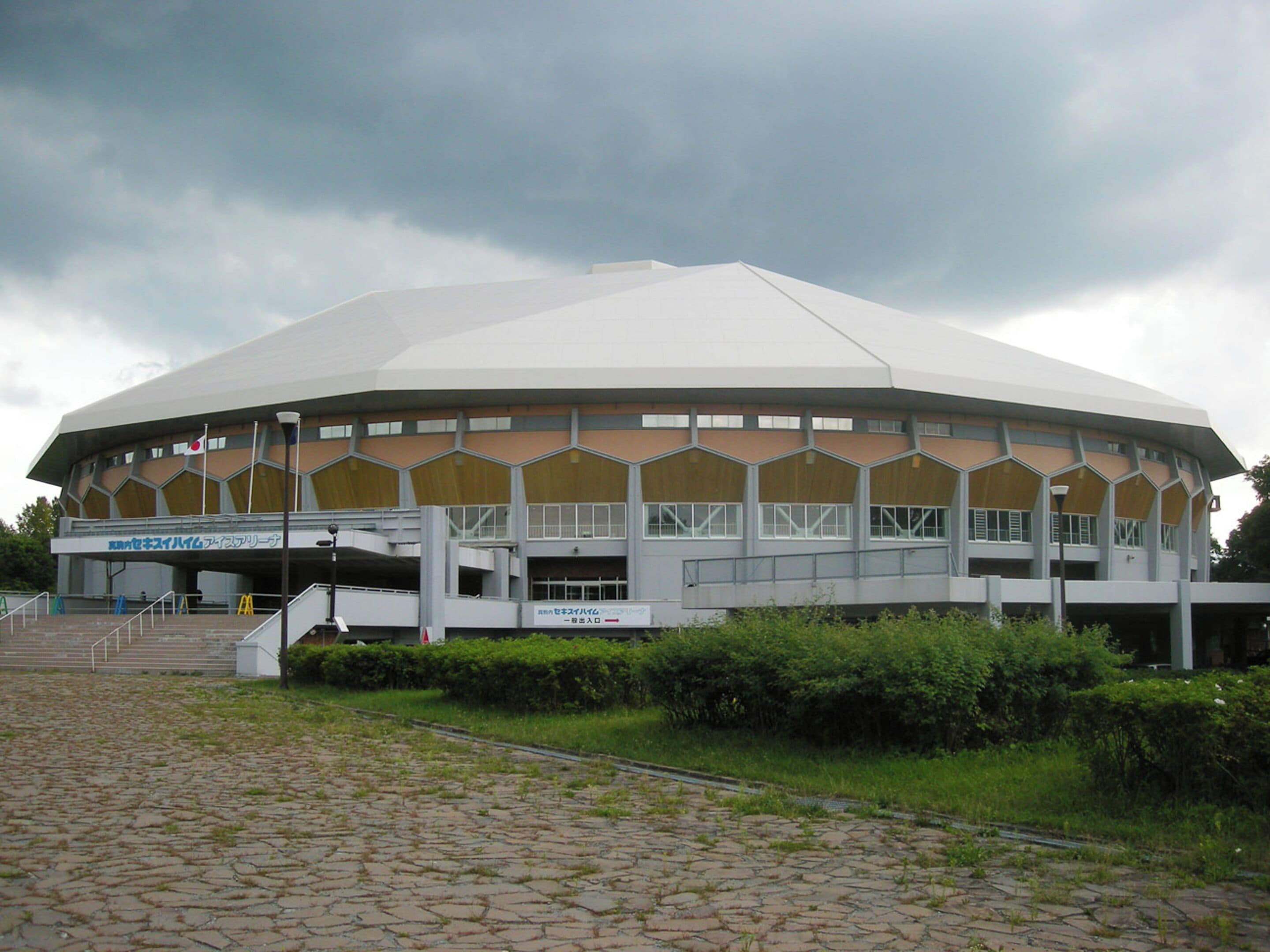 A large, circular building with a flat roof and multiple windows.