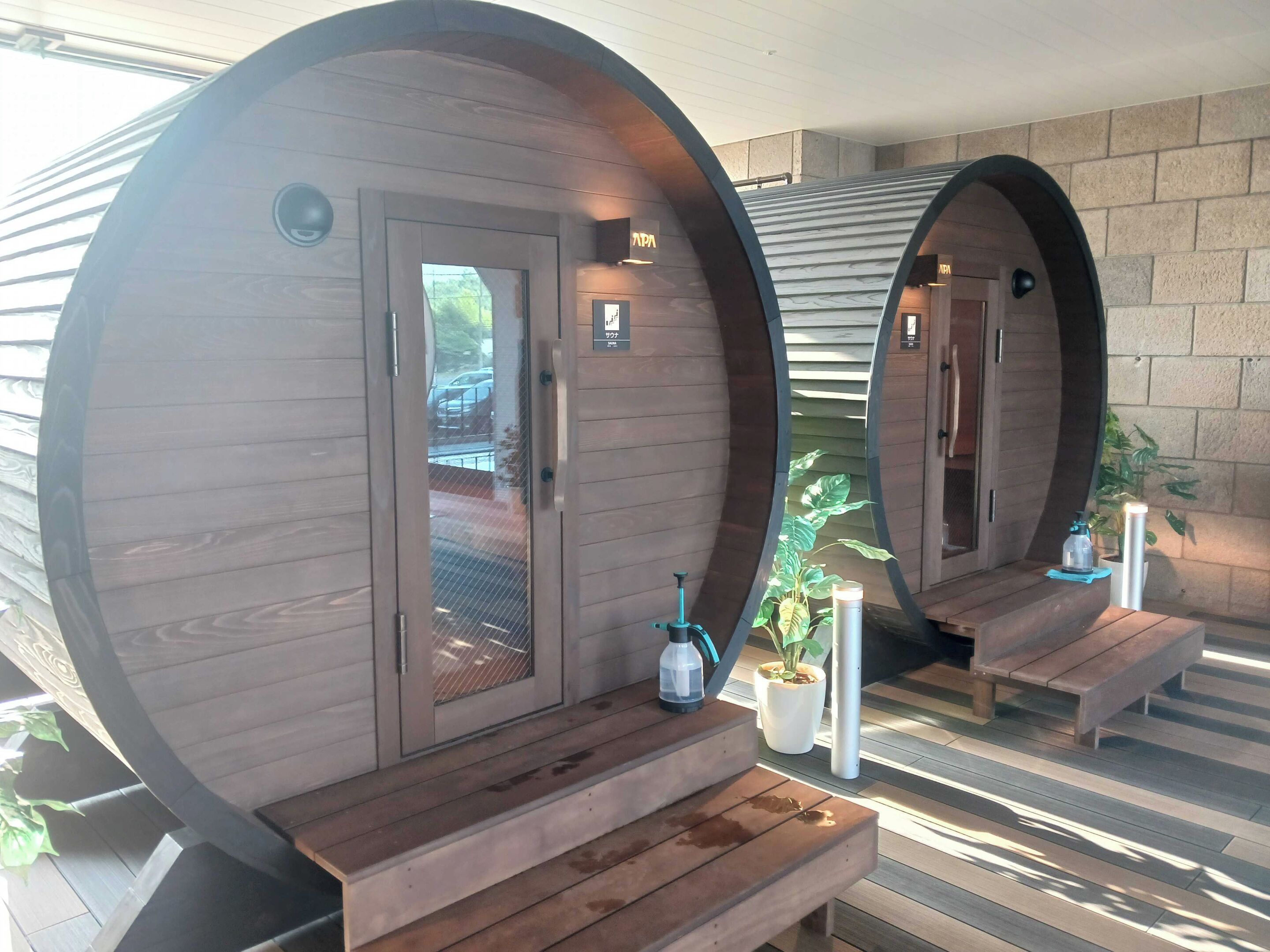 A spa area with wooden barrel-shaped rooms, each with a bench and a small table.