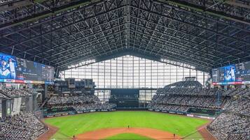 Un estadio de béisbol grande con techo alto y múltiples niveles de asientos.