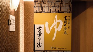Una pared con un letrero que indica la recepción y el vestíbulo, y otro letrero para un spa llamado SPA Genyono-u.