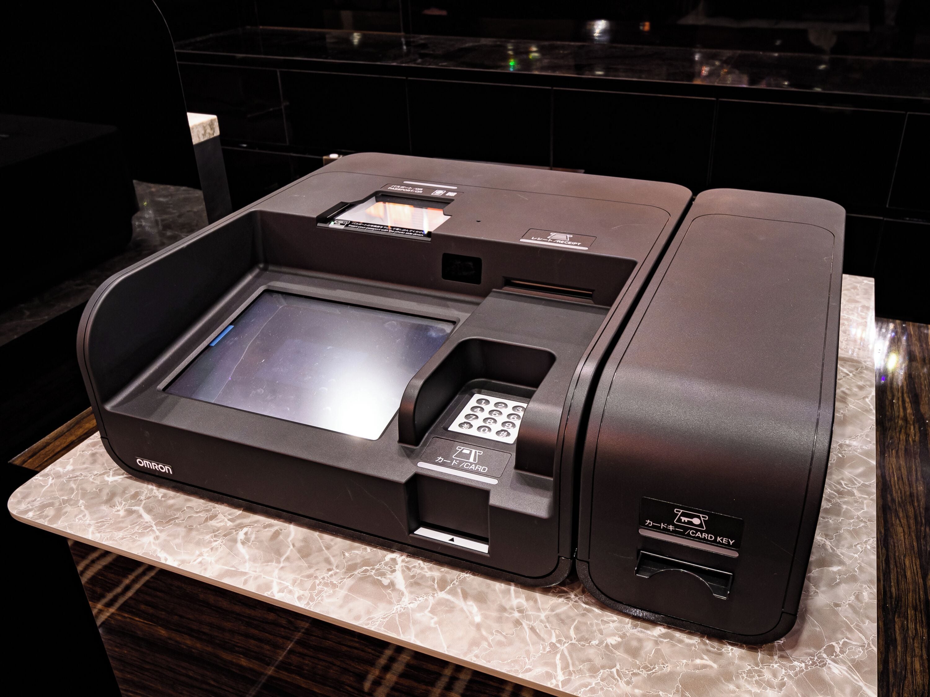 A self-service kiosk with a card reader, a receipt printer, and a card key slot.