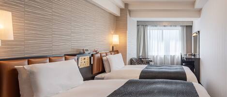 Una habitación de hotel con dos camas, un escritorio, una silla, una lámpara y un espejo.