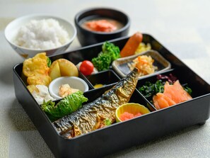 A bento box with various food items including fish, vegetables, and rice. - APA Hotel Sapporo Hosui Susukino Ekimae (Sapporo)