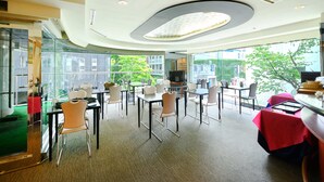 A modern conference room with glass walls, multiple tables, and chairs. - APA Hotel Sapporo Hosui Susukino Ekimae (Sapporo)