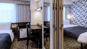 A hotel room with two beds, a desk, a chair, a desk lamp, a telephone, and a mirror. - APA Hotel Sapporo Odori Ekimae Nishi (Sapporo)