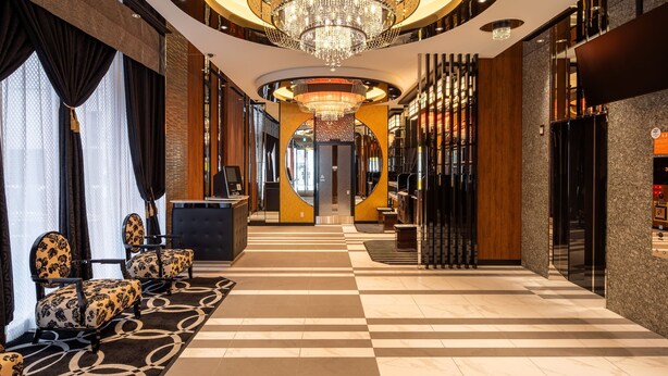 A hotel lobby with a check-in counter, seating area, and a grand chandelier. - APA Hotel Sapporo Odori Ekimae Nishi (Sapporo)