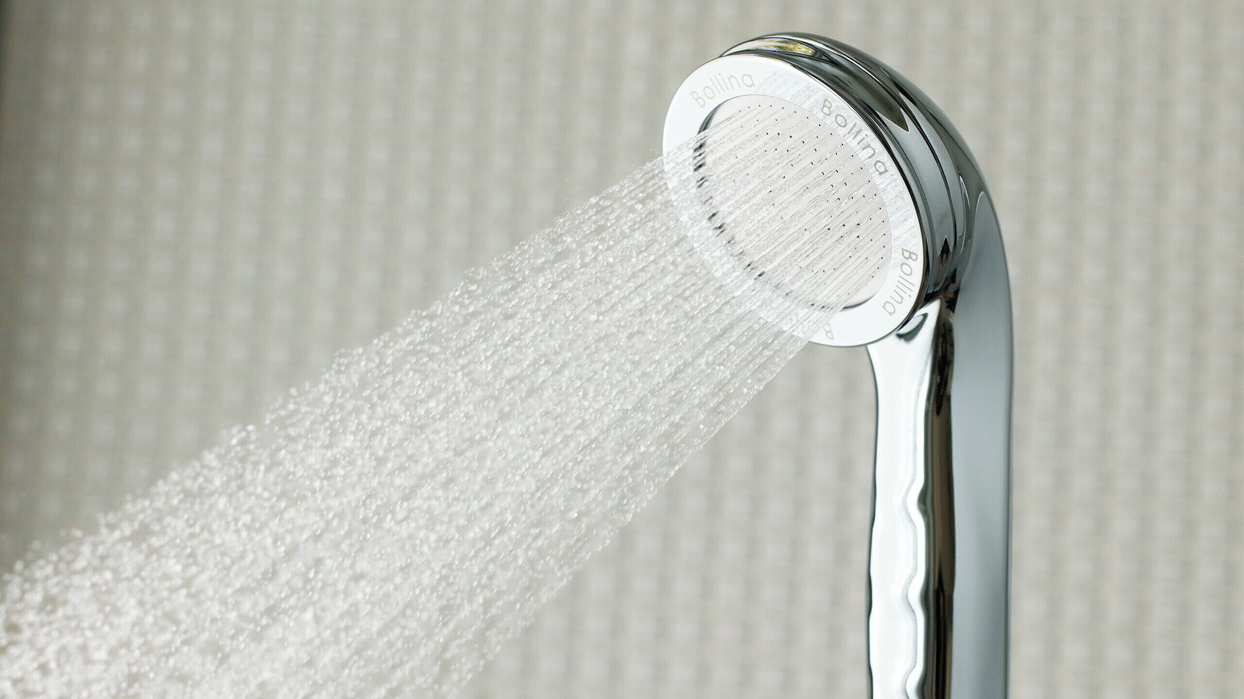 A showerhead with water flowing from it.
