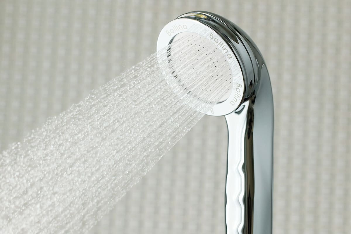 Un pommeau de douche d’où jaillit de l’eau.
