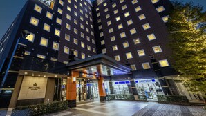 Et hotel med flere etager og et tydeligt skilt med teksten "APA HOTEL".