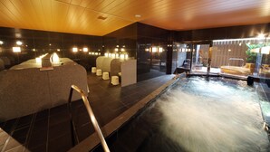 Et spaområde med jacuzzi, siddepladser og et træloft.