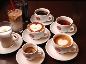 Ein Tisch mit verschiedenen Kaffeetassen und einem Glas Eiskaffee.
